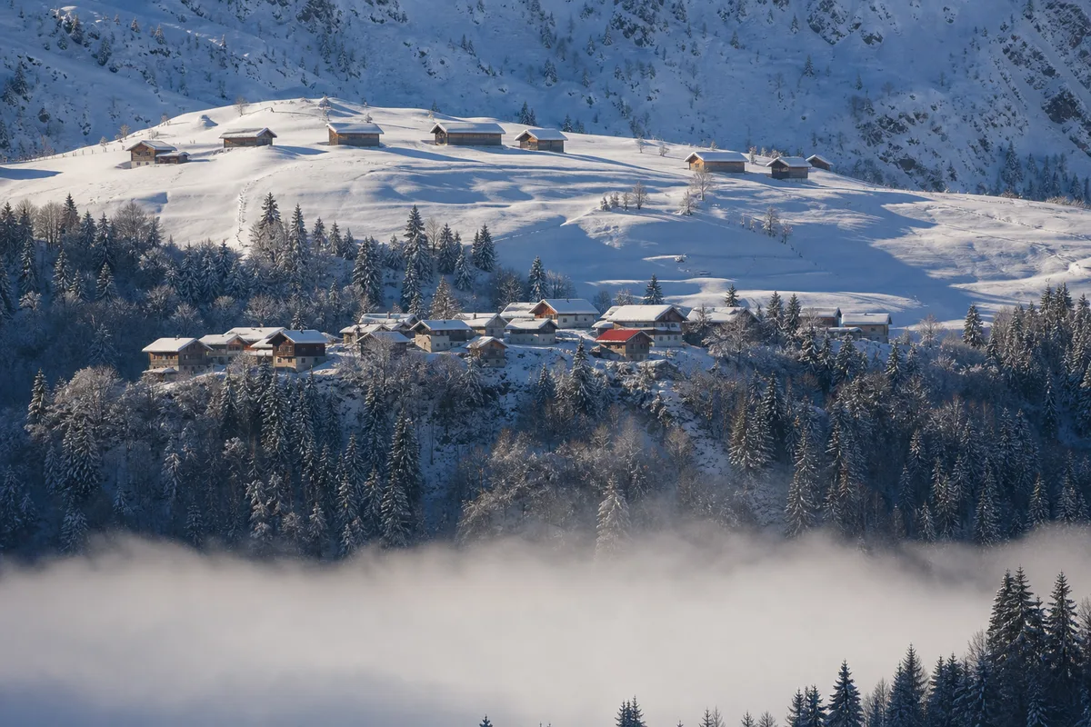 Vue hivernale des étages de Saint-Gervais, fond de vallée dans la brume givrante et hameau enneigé plus haut